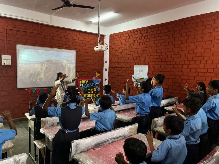 Hands up in a Nagazari classroom, the desks still in their wrapping