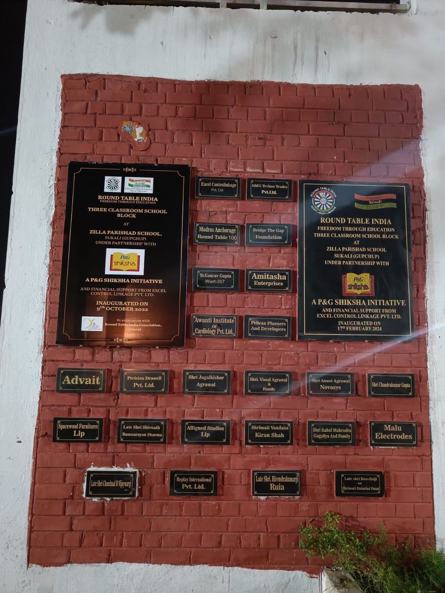 The donor plaque wall at one of the completed schools, each name cast in metal on the brickwork